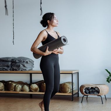 Woman holding a serene yoga pose in a dark studio.